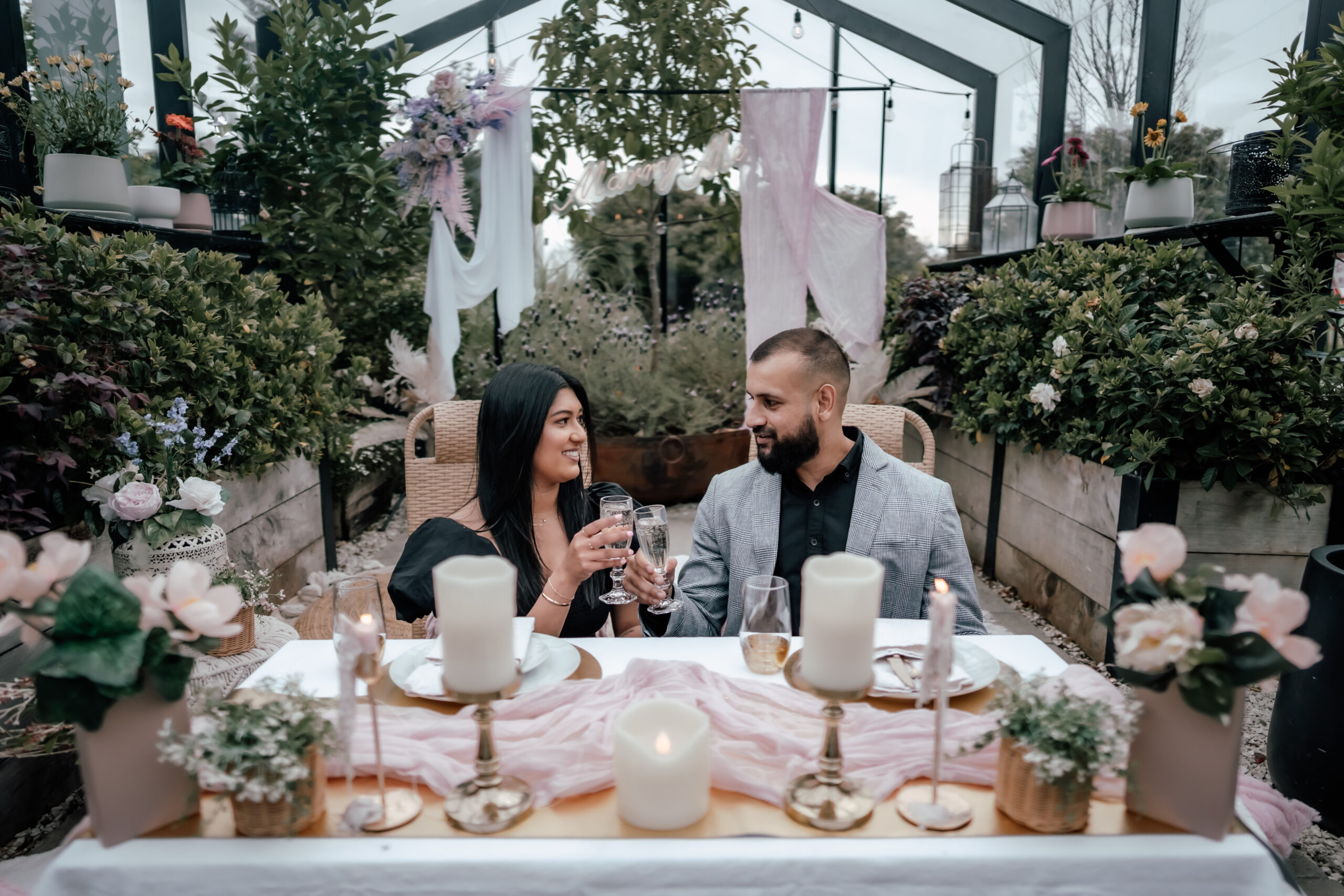 Romantic pink-themed greenhouse proposal at The Grange in Takapuna, New Zealand, with floral decor and surprise engagement moment captured by Auckland proposal photographer.