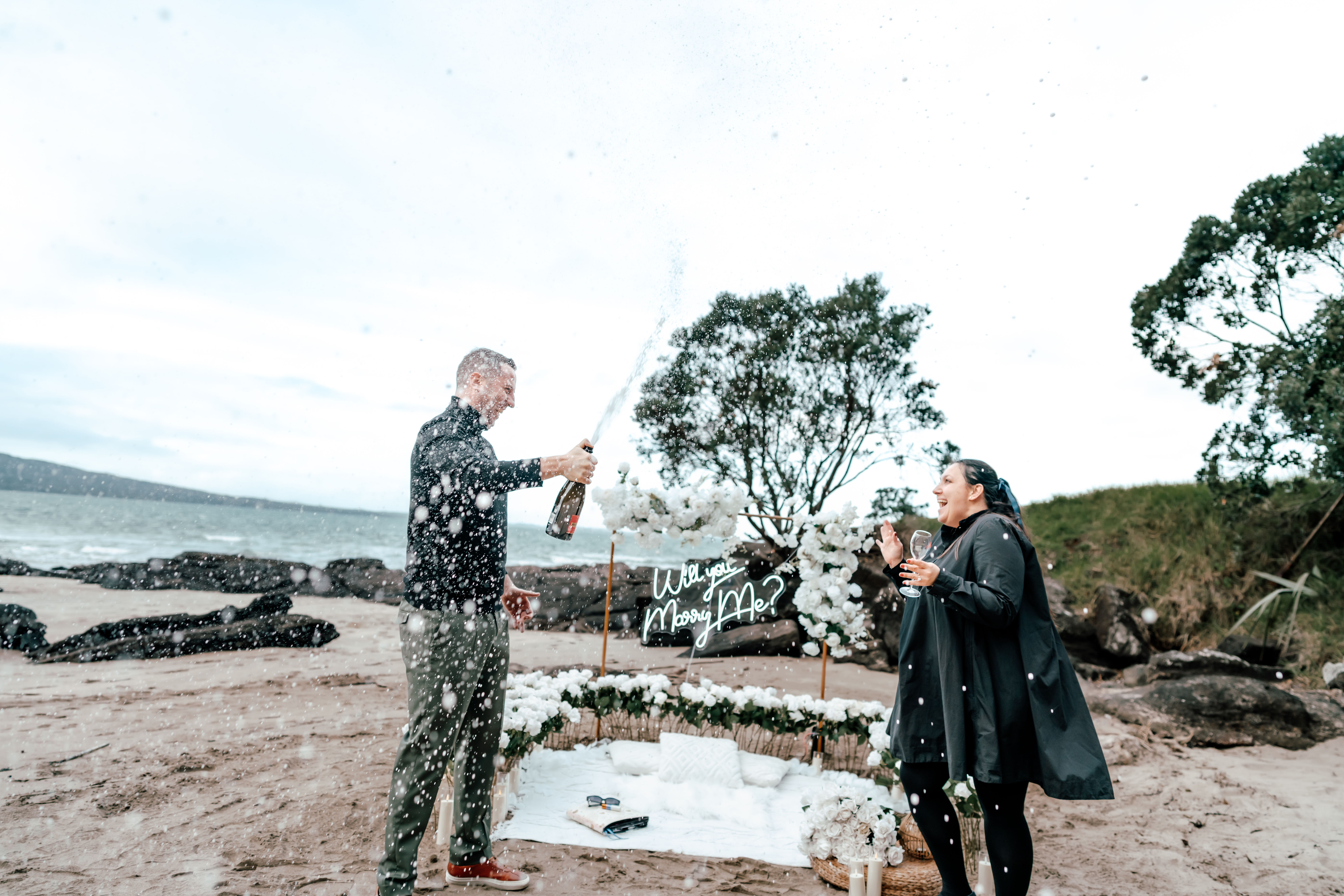 Surprise proposal on the beach at North Head with Daniel waiting and Ilona walking down in shock and joy