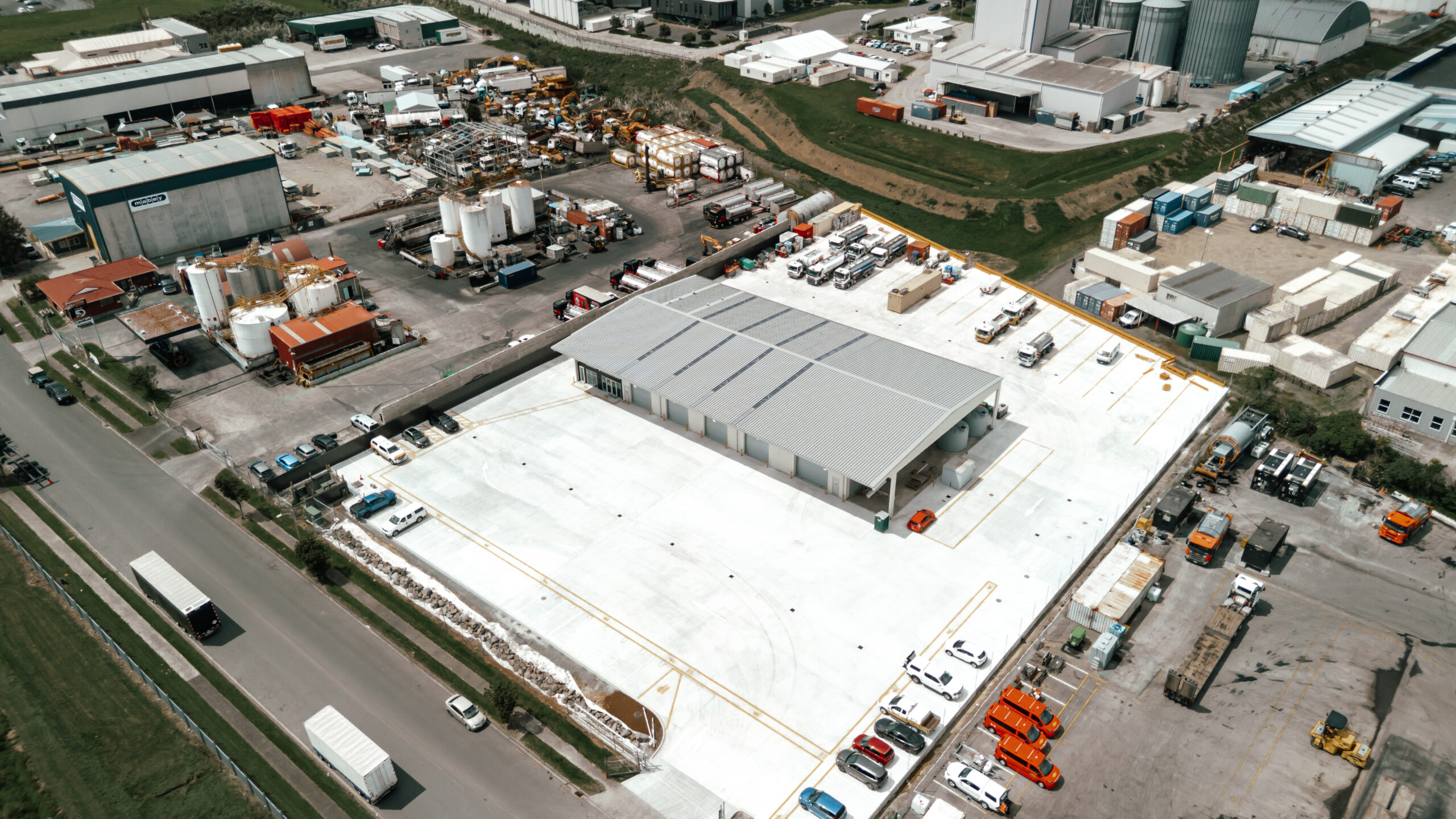 Drone photo showing Abbotts Drainage civil site with excavators and workers pouring concrete in Auckland