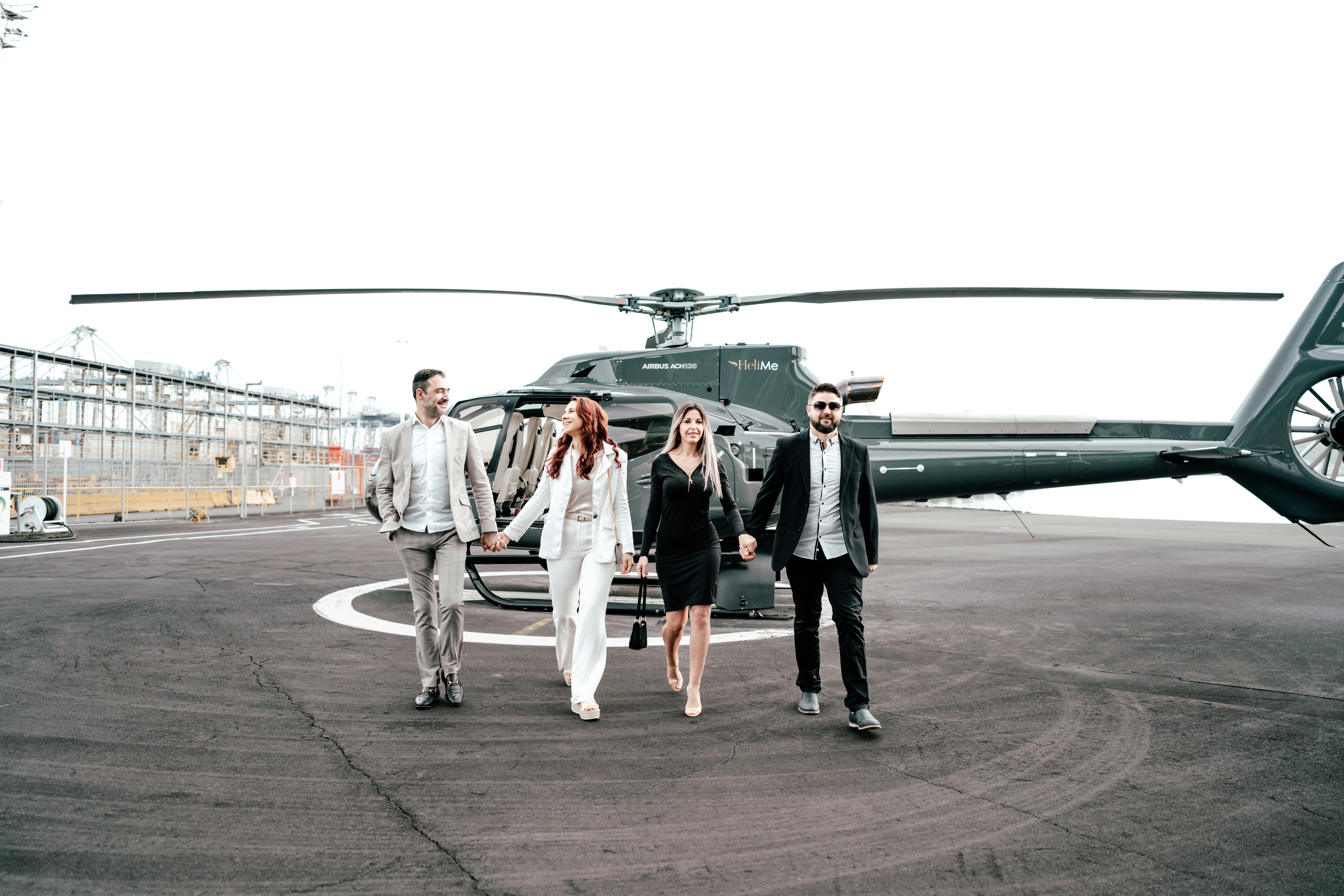 Auckland commercial videography shoot with two couples walking from a helicopter at Helicopter Me, captured by Zanthe Vorsatz Photography.