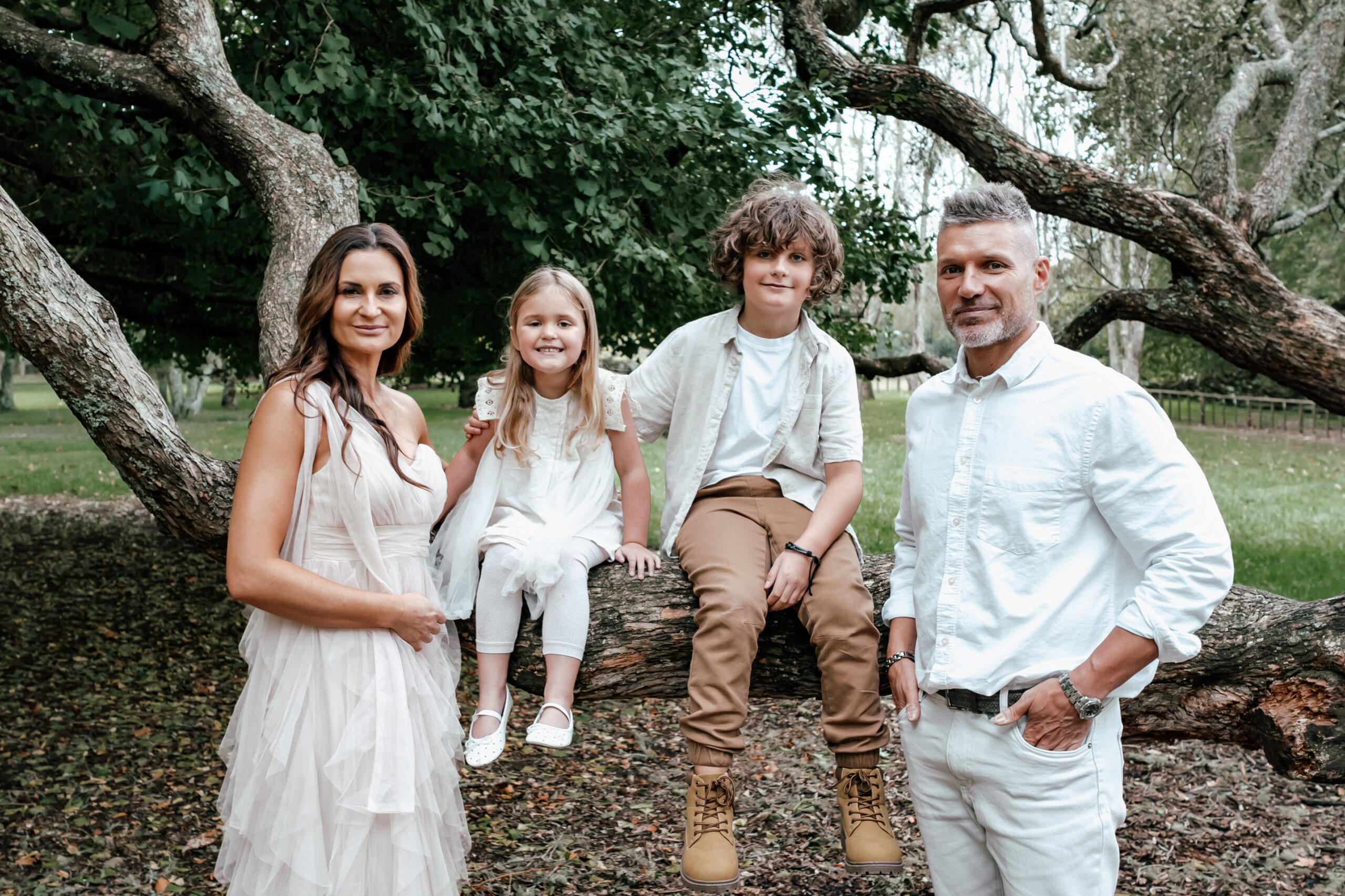 Family of four dressed in neutral tones during a photoshoot at Cornwall Park in Auckland captured by Zanthe Vorsatz Photography