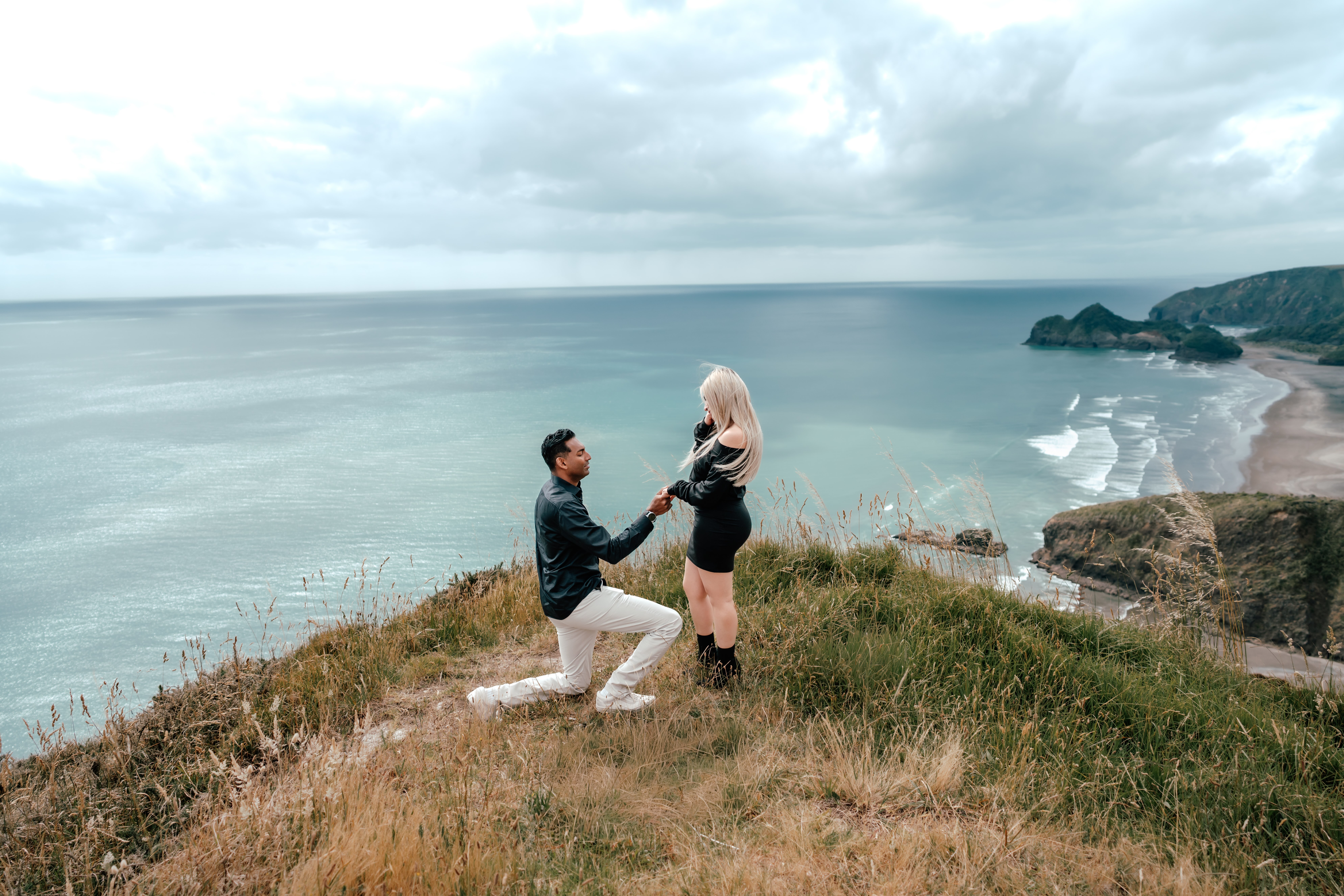 Ruwan proposing to Anabel during a helicopter proposal in New Zealand on a cliff top