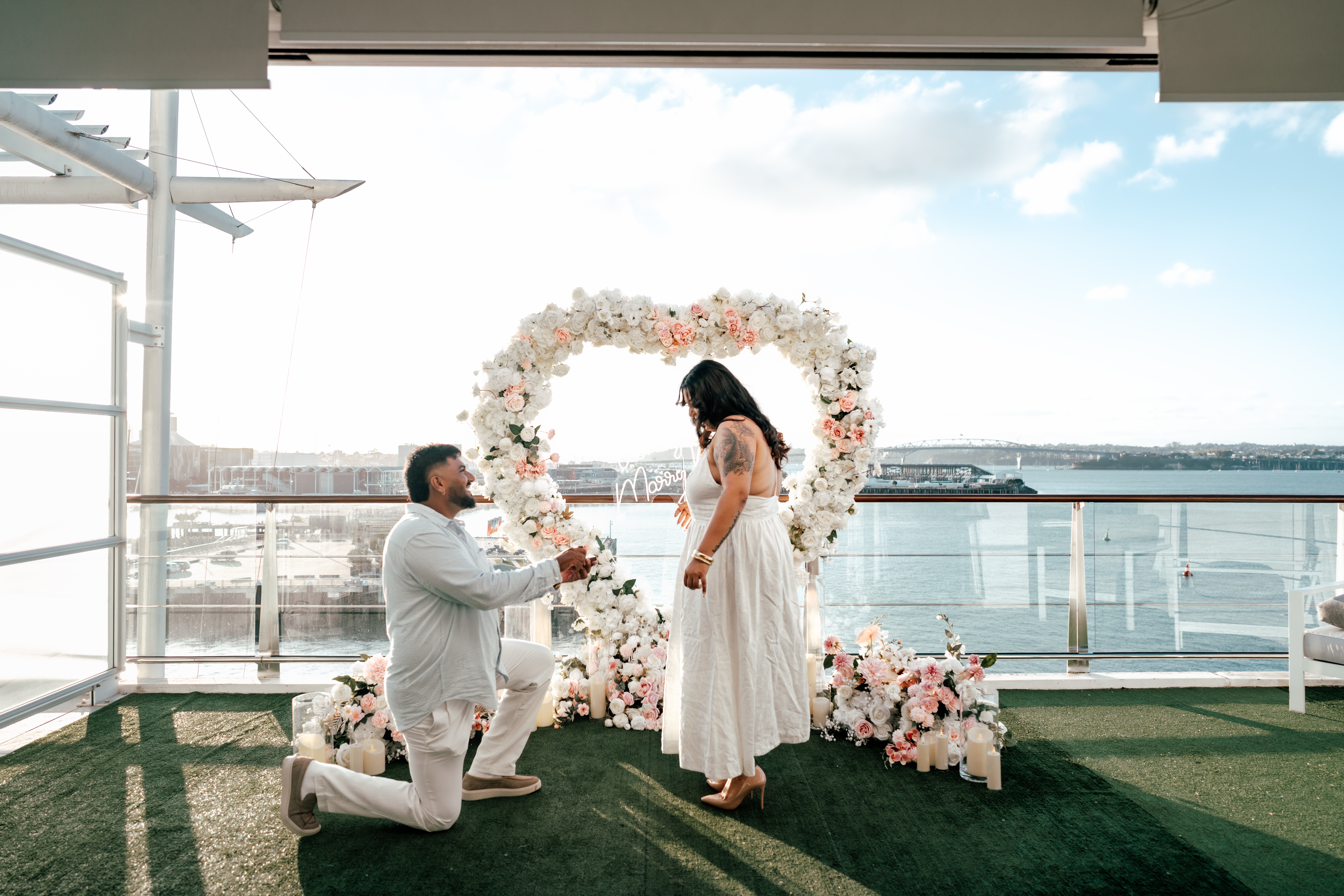 Romantic hotel room proposal overlooking Auckland Harbour Bridge captured by Zanthe Vorsatz Photography