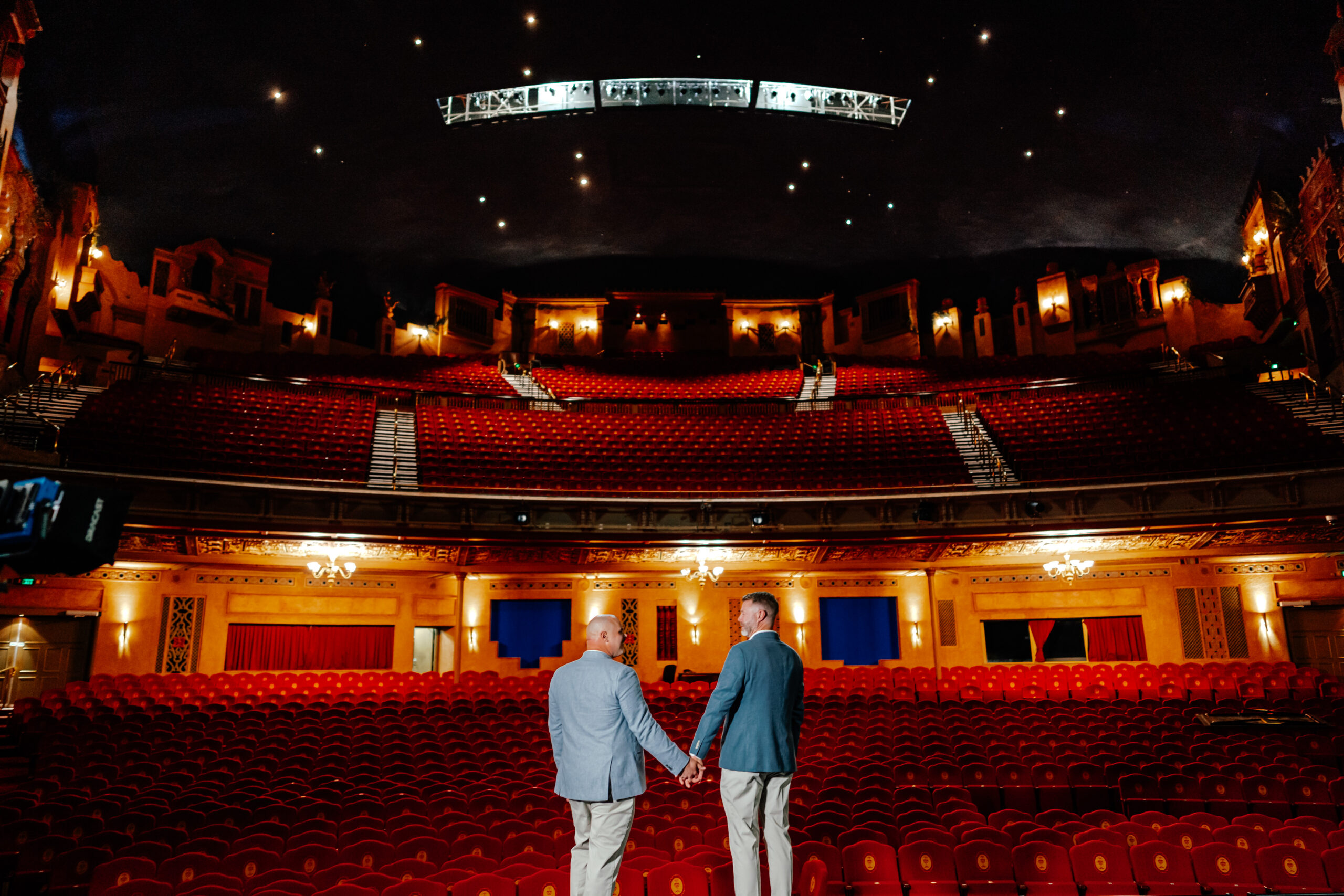LGBTQ couple standing on the Iconic Civic Theatre Stage in Auckland for their wedding photos